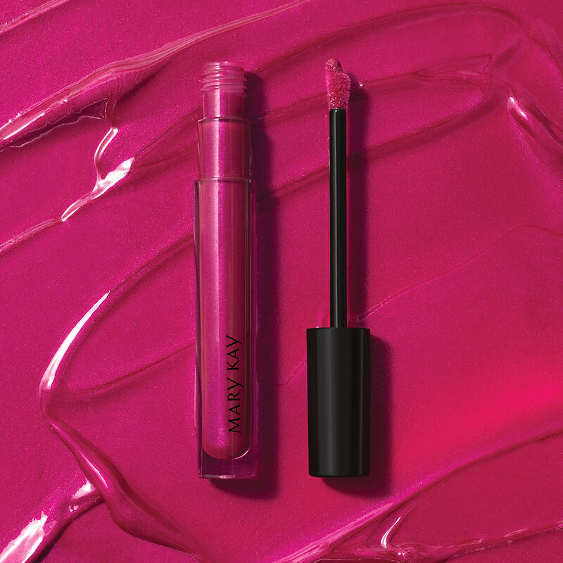 Open tube of Mary Kay Unlimited Lip Gloss in shade Berry Delight against accompanying shade rub.