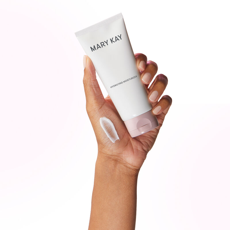Main tenant un tube de l&rsquo;Hydratant Mary Kay avec un frottis du produit sur la main