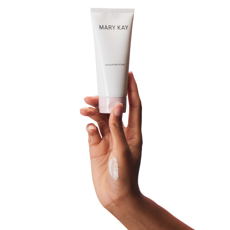 Main tenant un tube de l&rsquo;Exfoliant Mary Kay avec un frottis du produit sur la main