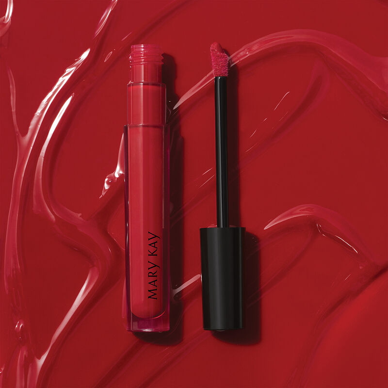Open tube of Mary Kay Unlimited Lip Gloss in shade Iconic Red against accompanying shade rub. image number null