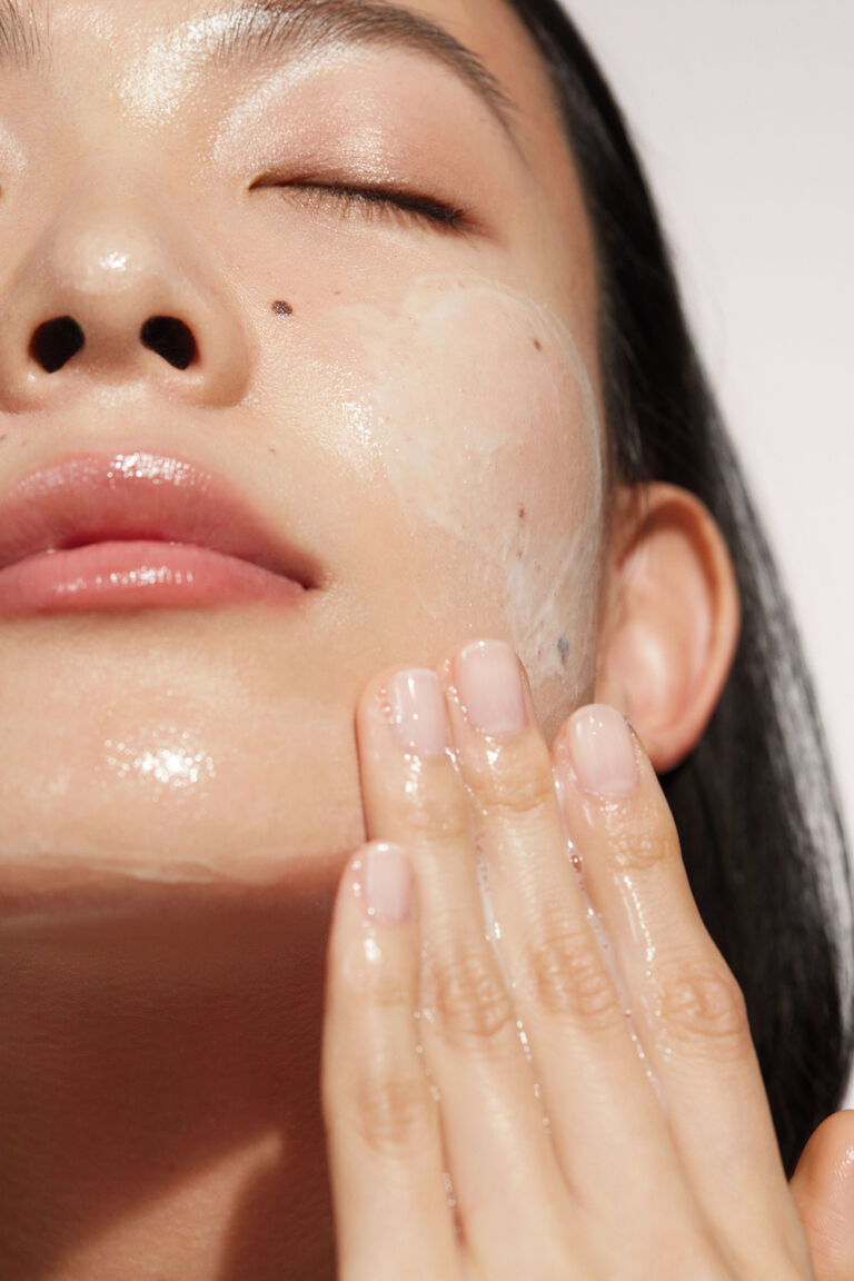 Gros plan d&rsquo;une femme appliquant le nettoyant de l&rsquo;Ensemble Miracle TimeWise Mary Kay.