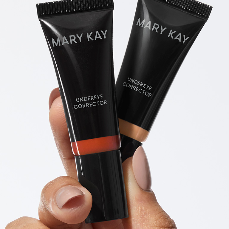 Hand holding both shades of Mary Kay Undereye Corrector